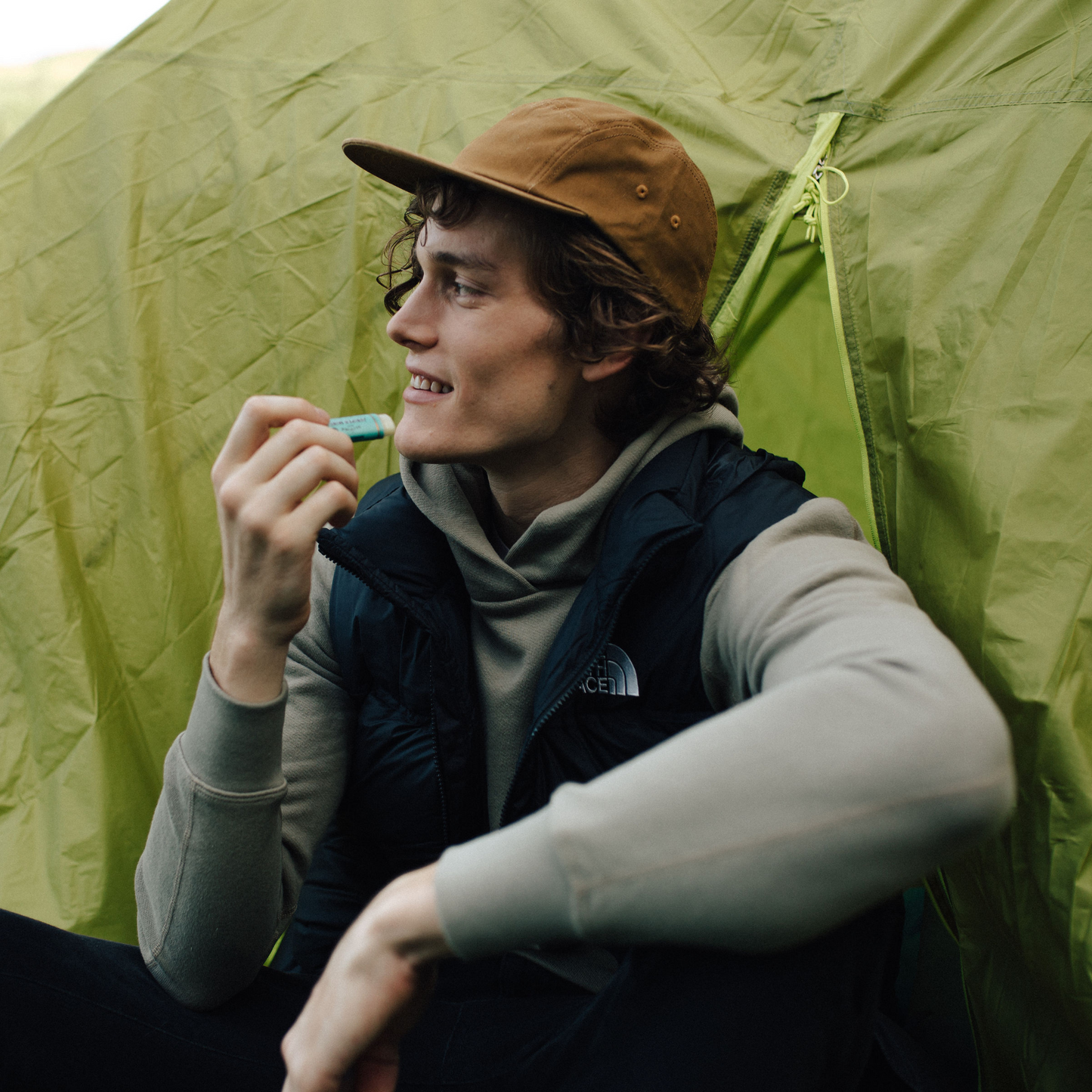 Model applying Olive Oil Lip Balm - Juniper Mint to their lips