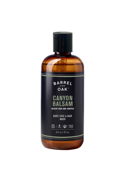 A 16 fl oz (473 ml) brown plastic bottle of Hair, Face and Body All In One Wash - Canyon Balsam with a black flip-top cap and dark label with green and white text; a balanced cleanser for body, face, and hair.