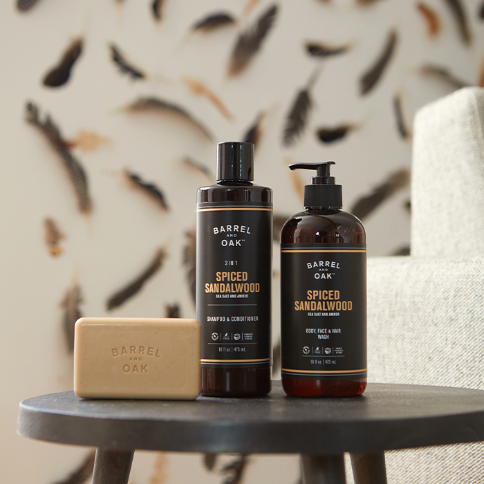 Barrel & Oak Spiced Sandalwood shampoo & conditioner, body, face & hair wash, and bar soap arranged on a dark table.