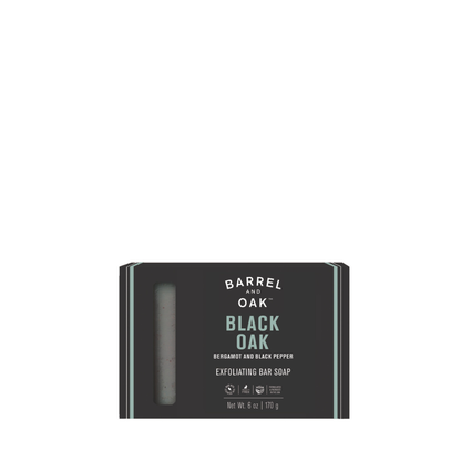 Exfoliating Soap Bar - Black Oak 6 oz, in black packaging with teal accents and a window to view the soap. Infused with bergamot, black pepper, charcoal powder, and made with sustainable palm oil.