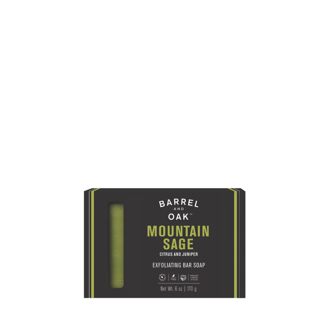 A black box of Barrel and Oak Exfoliating Soap Bar - Mountain Sage 6 oz. features citrus, juniper, and kaolin clay with a green bar visible through a window. Packaging shows product details and weight (6 oz/170 g).