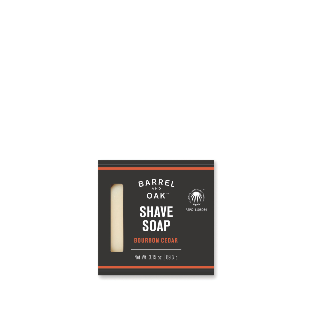 A 3.15 oz Classic Shave Soap - Bourbon Cedar. This natural, vegan shave soap features black packaging with orange accents and a window to view the soap inside.