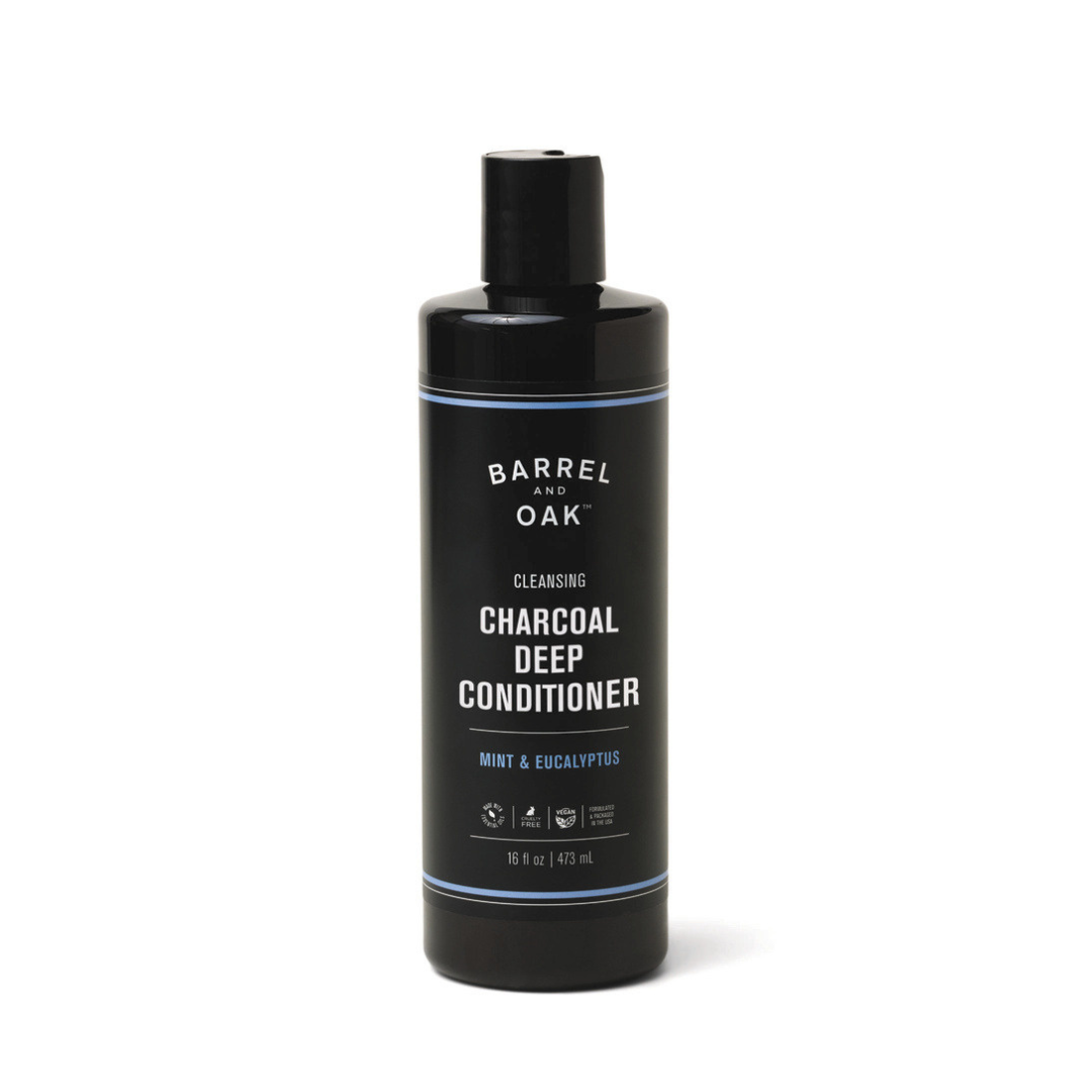 A black bottle of Charcoal Deep Conditioner - Mint & Eucalyptus 16 oz features white text and a flip-top cap, providing deep conditioning with argan oil, mint, and eucalyptus for revitalized hair.