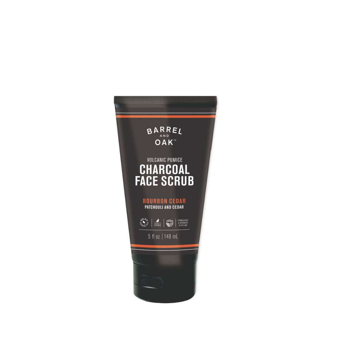 A sleek black tube of Volcanic Pumice Charcoal Face Scrub - Bourbon Cedar, 5 fl oz (148 mL), featuring product name, ingredients, and label details.