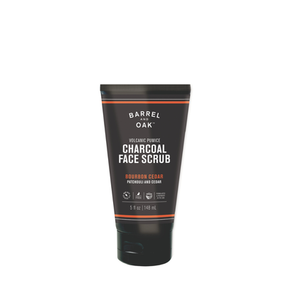A sleek black tube of Volcanic Pumice Charcoal Face Scrub - Bourbon Cedar, 5 fl oz (148 mL), featuring product name, ingredients, and label details.