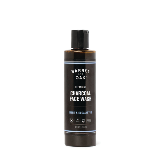 A brown bottle of Cleansing Charcoal Face Wash - Mint & Eucalyptus 8 oz, with a black flip-top cap and label in white and blue text, featuring eucalyptus and peppermint oils and a fresh mint scent.